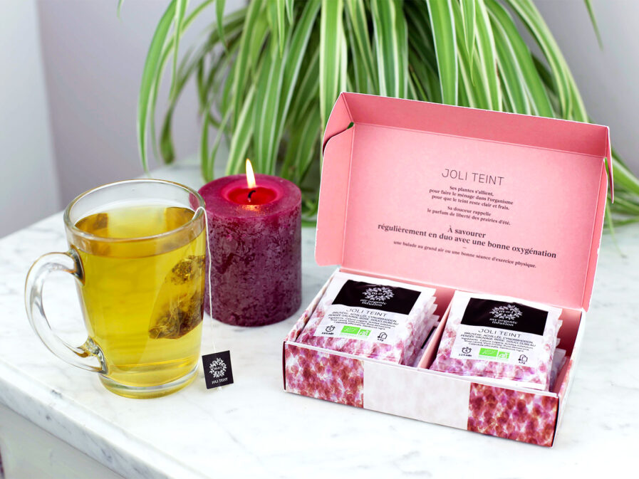 Coffret Joli Teint de 12 infusettes ouvert sur un table en marbre