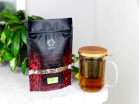 Infusion Rouge Rubis dans une tasse transparente avec le sachet vrac